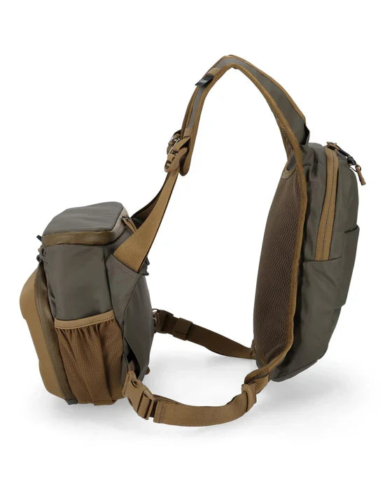 Simms Headwaters Chest Pack in olive and brown tones, featuring multiple zippered compartments, breathable mesh back panel, and adjustable straps designed for fishing tackle storage and easy access.