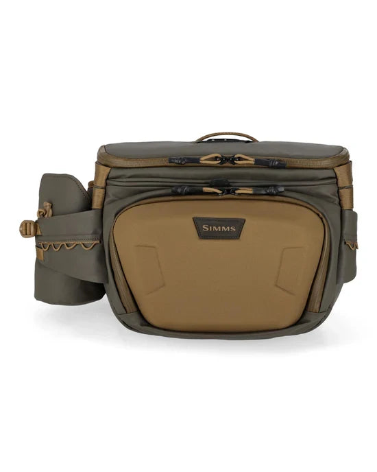 Simms Headwaters Hip Pack in olive and tan colors, featuring multiple zippered compartments, adjustable waist strap, and water-resistant fabric designed for fishing tackle organization.