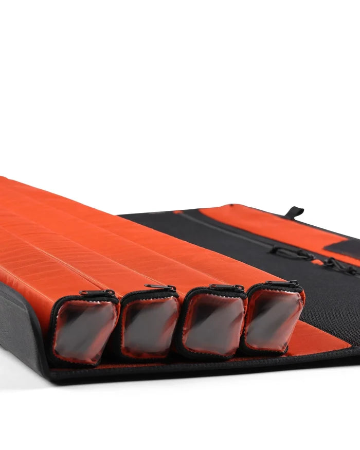 Simms Riverkit Rod Roll unfolded on a white background, showing four padded orange compartments designed to securely store and protect fishing rods and tackle.