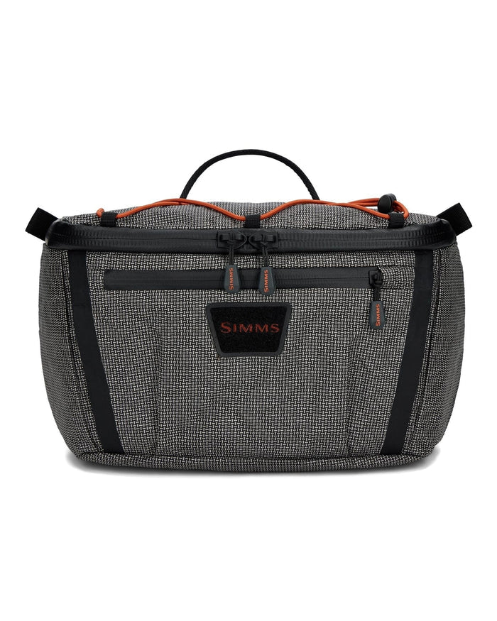 Simms Scout Hip Pack in gray and black with orange accents, featuring multiple zippered compartments and a top handle, designed for organizing fishing tackle and gear.