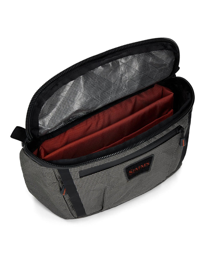 Simms Scout Hip Pack in grey fabric with black trim, shown open to reveal spacious interior with red divider compartments and zippered pocket on the front.