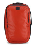 Simms Tailwind Backpack in bright orange with multiple zippered compartments, a black logo patch on the front, padded shoulder straps, and a sleek, durable design ideal for fishing tackle and outdoor use.