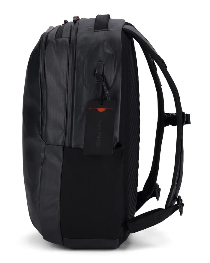 Simms Tailwind Backpack in black, featuring multiple zippered compartments, padded shoulder straps, and a side mesh pocket designed for fishing tackle and outdoor gear storage.