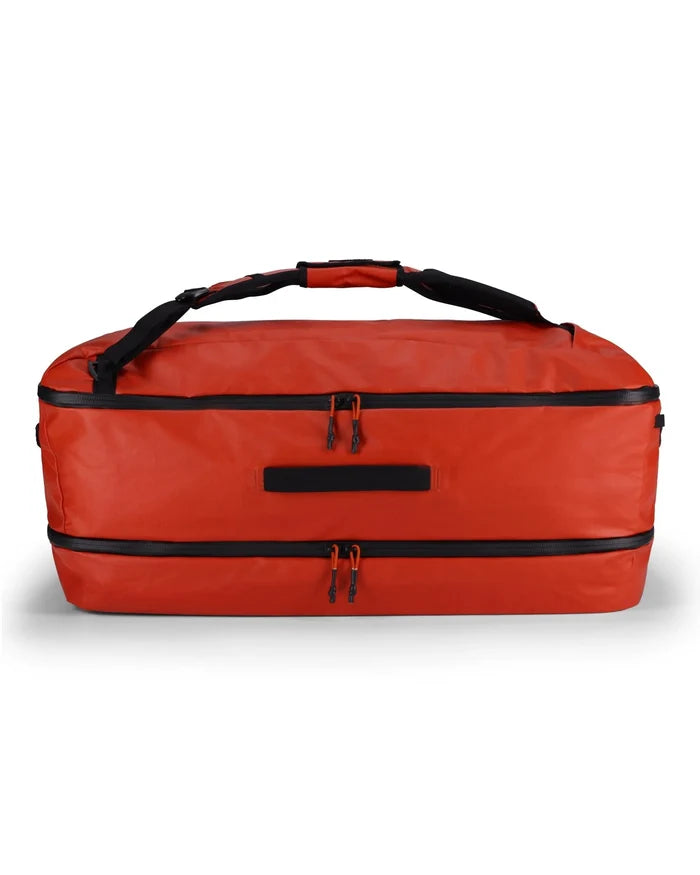 Simms Tailwind Duffel 80L in bright orange with dual zippered compartments, padded carry handle, and durable water-resistant material for secure fishing tackle and gear storage.