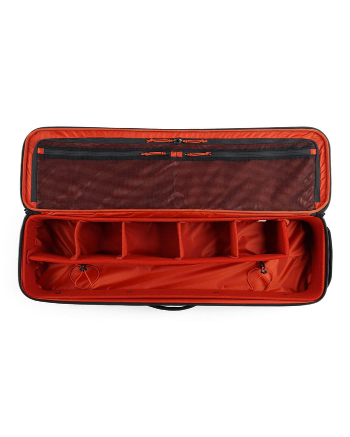 Open Simms Tailwind Rod & Reel Vault showing bright orange interior with multiple padded compartments and zippered mesh pockets designed for organized storage of fishing rods and reels.