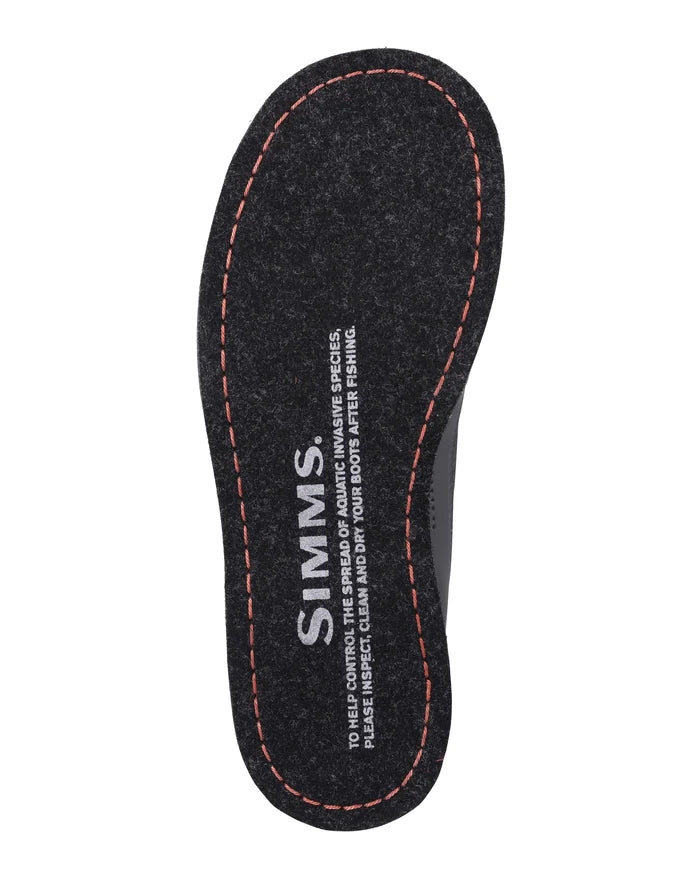 Simms Tributary Wading Boot - Felt Sole shown from above, featuring a black felt sole with orange stitching and printed text for aquatic species protection guidance.