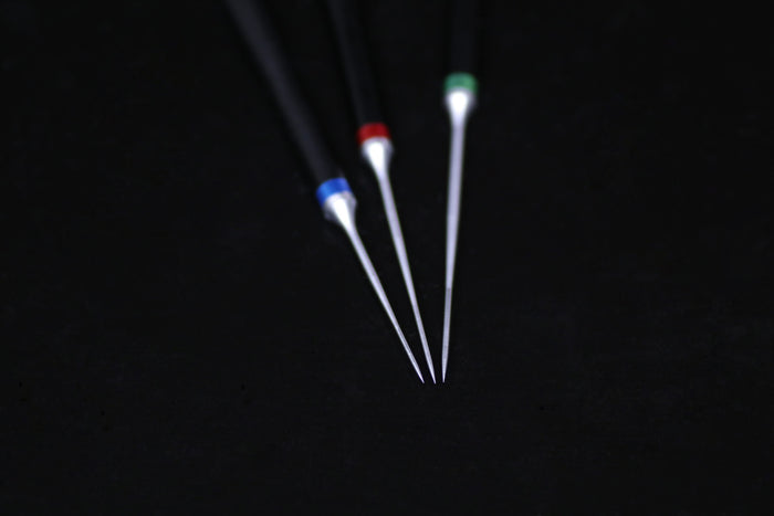 Three fine-tipped Smhaen Dubbing Needles with black handles and colored bands in blue, red, and green, used for precise fishing tackle applications.