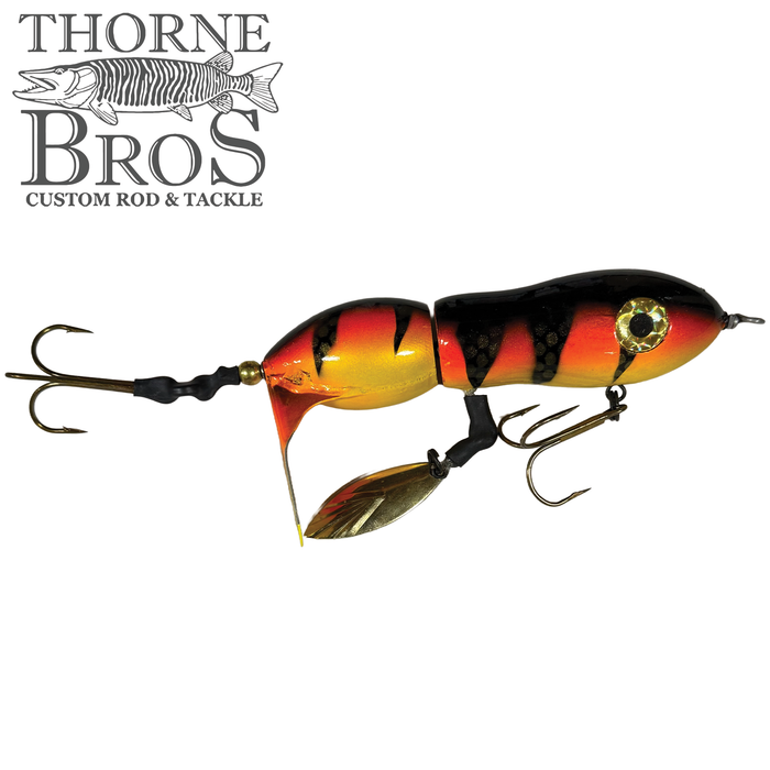 Snaggle Tooth Tackle Mini Beast Prop Bait featuring segmented body with orange, yellow, and black stripes, dual treble hooks, and a small metal propeller for enhanced fishing tackle performance.