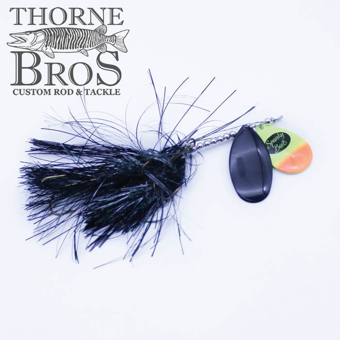 Close-up of Spanky Baits Lil' Angry 89 fishing lure featuring a black feathered skirt, a spinner blade with yellow and orange coloring, and a black spinning blade, designed for musky fishing.