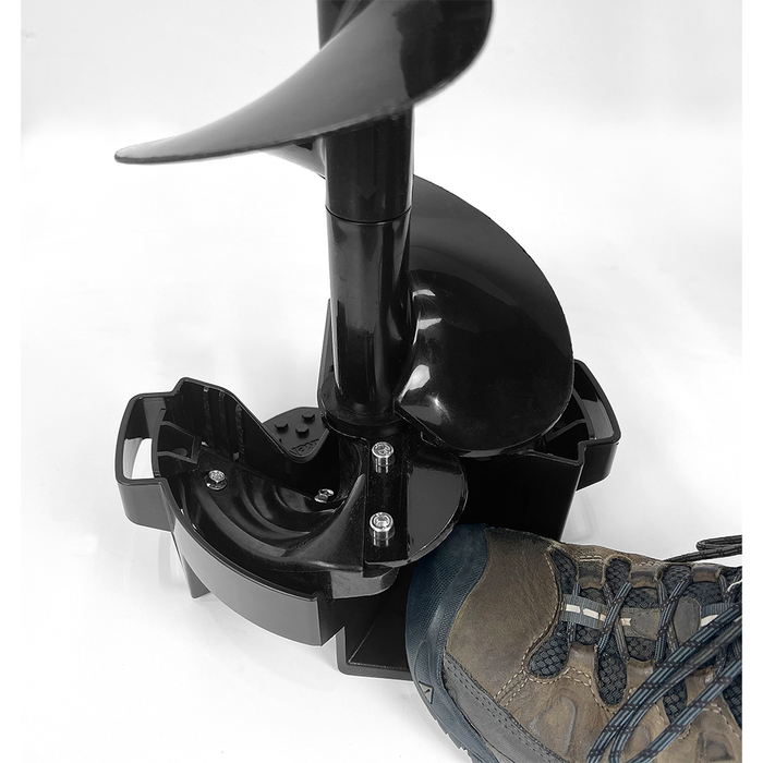 Close-up of a black Strikemaster Magnet Snap Cover (Lite-Flite) attached to a fishing auger blade, shown with a hiking boot for scale, highlighting durable construction for fishing tackle use.