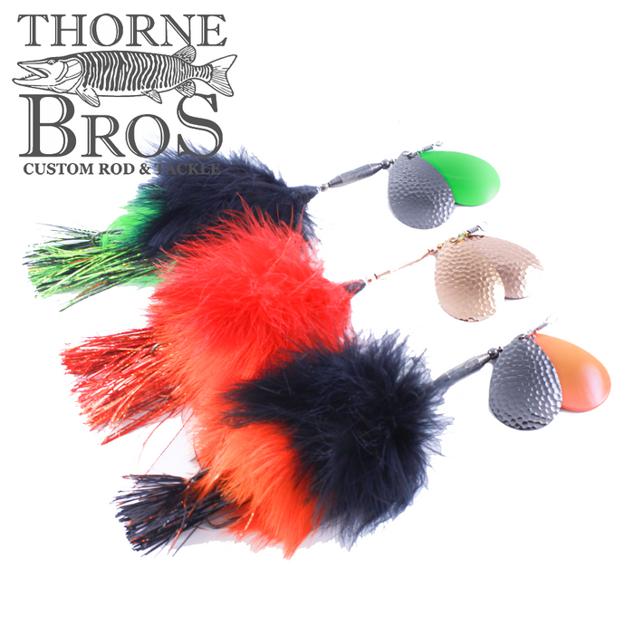 Three brightly colored fishing lures with marabou feathers in green, red, black, and orange beside textured spinner blades, labeled TB Baits Perfect #8 - Marabou.