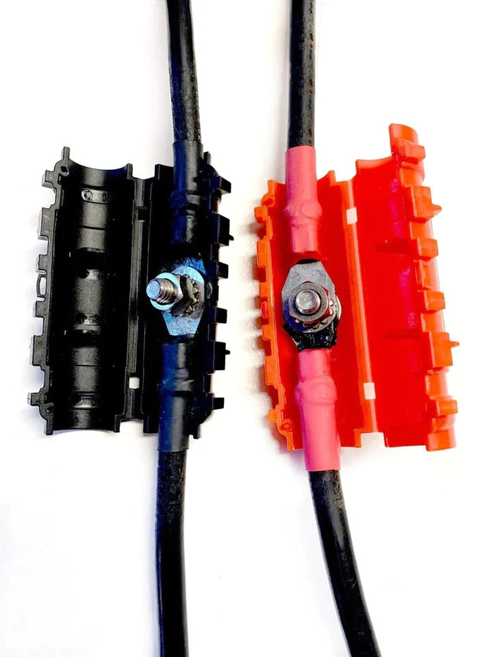 Close-up view of TH Marine HYDRA Battery Cable Extender HCE-K-DP showing two battery cables with protective black and red insulated covers secured by metal bolt connectors.