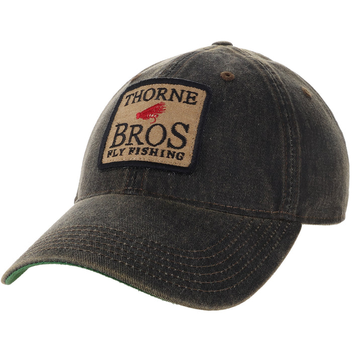 Thorne Bros. Fly Fishing Old Favorite Legacy Hats featuring a dark, weathered fabric with stitched front patch displaying the brand logo and fly fishing graphic.
