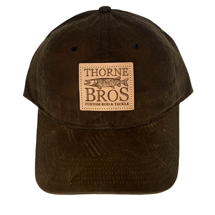 Brown waxed fabric baseball cap featuring a tan leather patch with "Thorne Bros. Logo Richardson Leather Patch" embossed along with a fish design and "Custom Rod & Tackle" text.