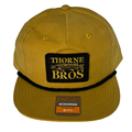 Thorne Bros Richardson Umpqua w/Rope brown fishing hat with black embroidered patch featuring a musky fish design and breathable eyelets for outdoor fishing activities.