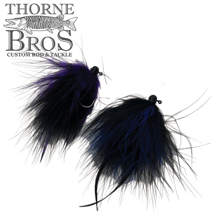Two Thorne Brothers Tungsten Marabou Jigs featuring black and dark purple marabou feathers, designed as custom fishing lures for musky and ice fishing tackle.