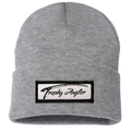 Trophy Angler Knit Stocking Cap in light grey knit fabric with a folded cuff featuring a stitched rectangular patch embroidered with "Trophy Angler" text in black script.