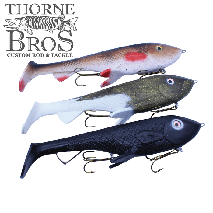 Three detailed fishing lures arranged vertically with lifelike colors and treble hooks, designed as Trophy Systems Bait Co. 15" AC-130 for musky fishing.
