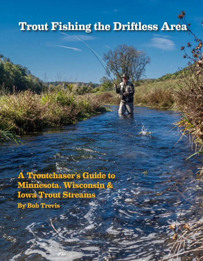 Cover of Trout Fishing The Driftless Area book showing an angler fly fishing in a clear stream surrounded by green and brown foliage under a blue sky.