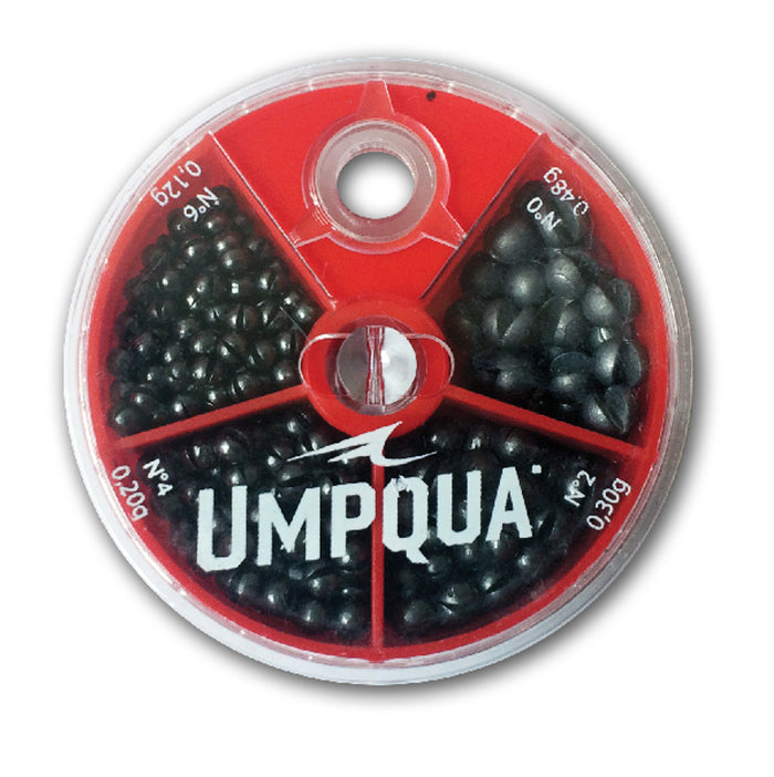 Round red plastic container with five compartments holding various sizes of black fishing weights, labeled "Umpqua 4-Way Split Shot Assortment," used for fishing tackle.