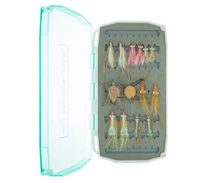 Open waterproof fly box displaying a variety of colorful fishing flies and lures arranged neatly inside, labeled as Umpqua Hosted Fly Assortment.