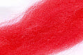 Close-up of bright red Wapsi Fuzzy Fiber material showing fine, soft, and fuzzy synthetic fibers used for fly fishing lures and fishing tackle.