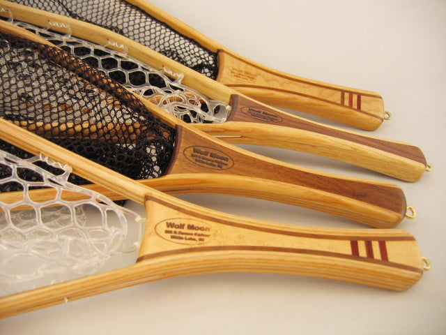 Close-up view of multiple wooden fishing nets with clear and black mesh, featuring the Wolf Moon Oxbow 10 inch Net among other high-quality fly fishing nets with smooth varnished handles.