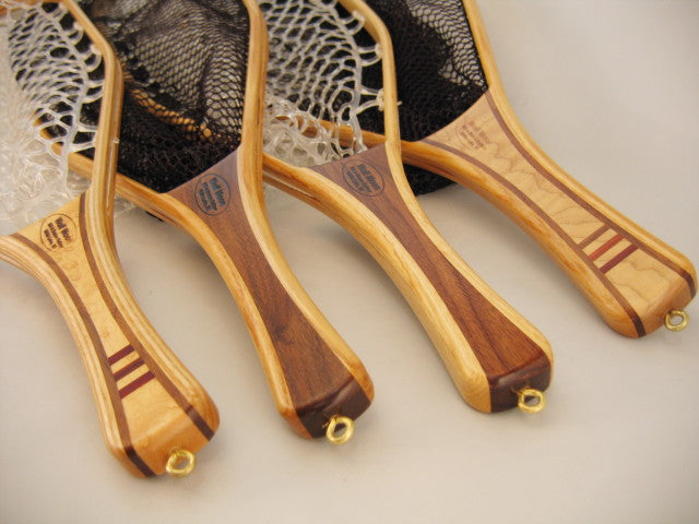 Close-up of four wooden handles of Wolf Moon Oxbow 10 inch Net fishing nets with smooth polished finish and woven mesh nets, designed for musky tackle and fly fishing.