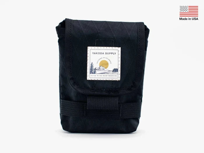 Yakoda Utility Pouch in black with front flap closure and sewn patch logo, made from durable fabric and designed for organizing fishing tackle and gear.