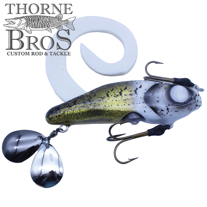 Zilla Baits Gladiator (Mini & Standard) fishing lure with a curved white tail, metallic green and silver body, and two sharp treble hooks, designed for musky fishing.