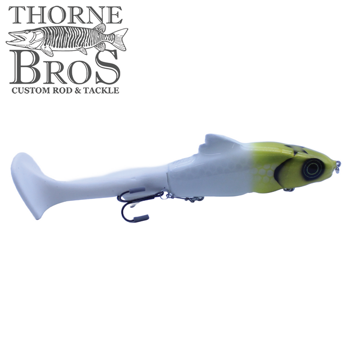 Zilla Baits Hooker fishing lure in white and yellow with realistic eyes and a soft paddle tail, designed for musky and freshwater fishing.
