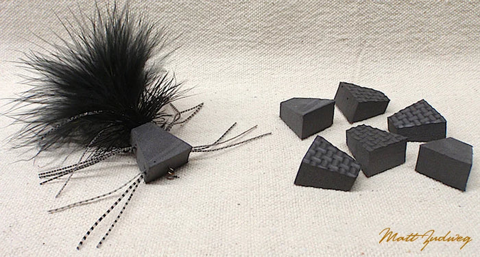 Black Zudbubbler Popper Bodies fishing lure components with textured surfaces and feathered accents, designed for musky and fly fishing tackle.